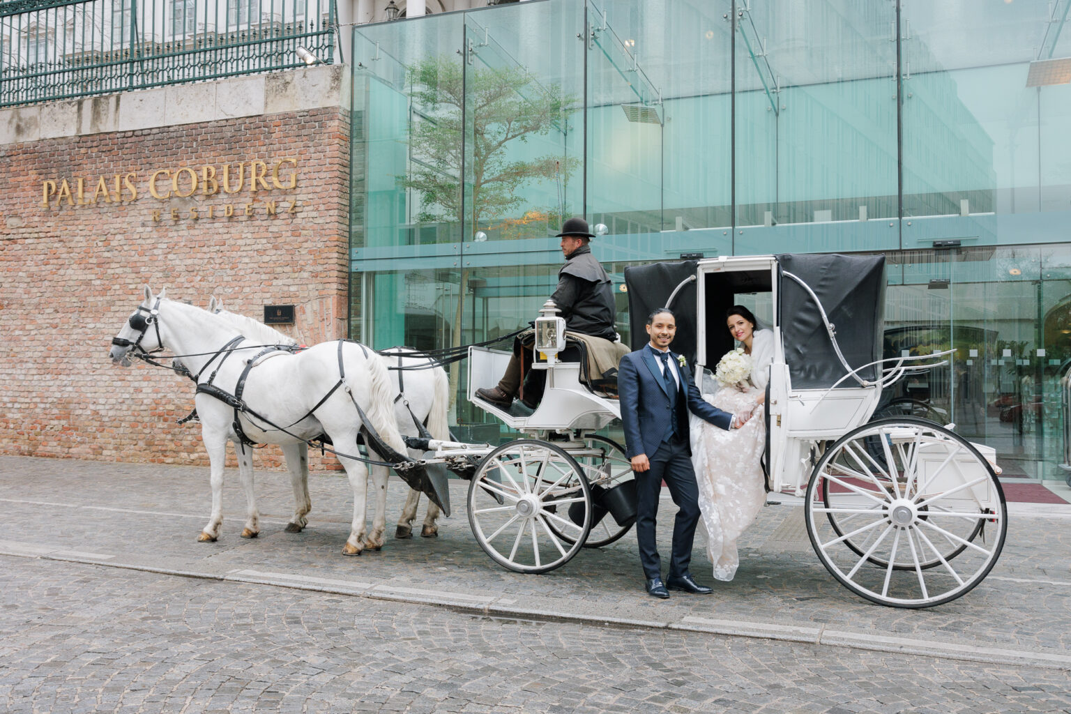 Coppia di sposi in carrozza di fronte al loro Hotel Palais Coburg Residenz