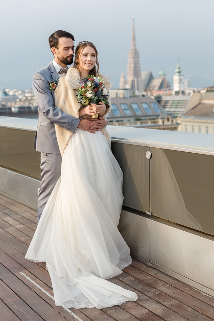 Just married bride and groom hugging on the rooftop terrace at Hotel Ritz Carlton in Vienna